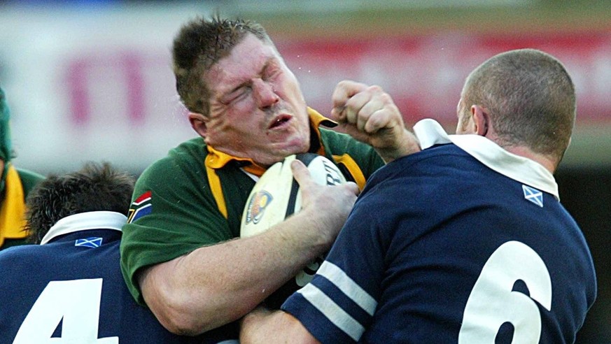 South African tight head prop, Richard Bands (C) tries to break through the tackle of Scotlands lock Scott Murry (L) and flank Jason White (R)during the friendly rugby international between South Afri ...