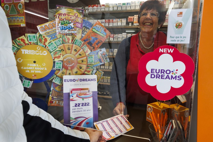 Un membre de la loterie romande presente le nouveau jeu de la loterie romande EURODRAMS a Josephine, kiosquiere, avant son lancement, ce lundi 16 octobre 2023 a Cheseaux-sur-Lausanne pres de Lausanne. ...