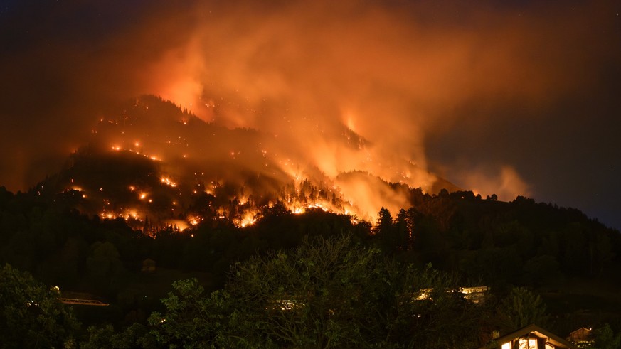 De la fumee et des flammes s'echappent de la foret en feu au dessus des communes de Bitsch et Ried-Moerel ce lundi 17 juillet 2023 depuis Naters. Un incendie de foret s'est declare lundi au- ...
