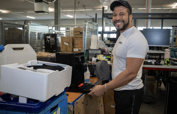 Guilherme Barreto vérifie que les retours sont complets et ne présentent pas de défauts - ici, il nettoie une machine à café qui a été retournée.