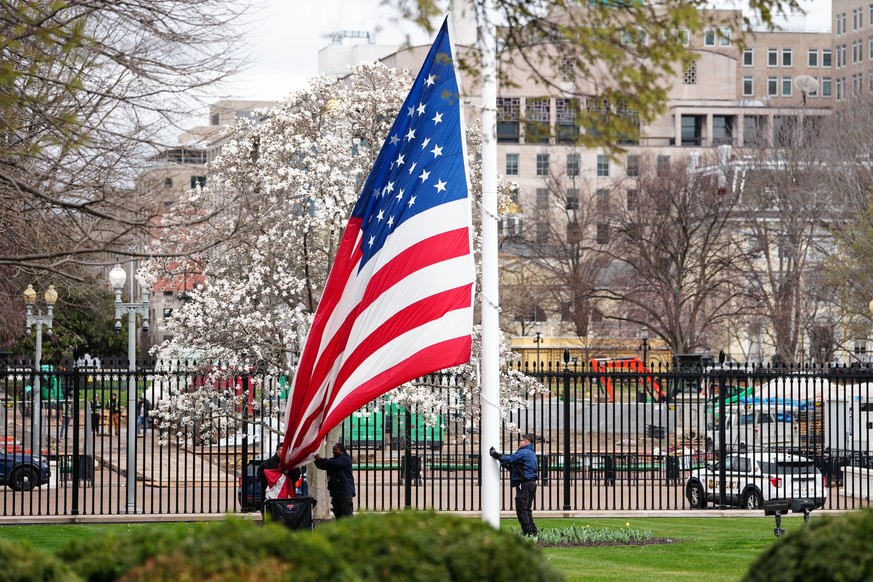 epa12825521 White House grounds staff lower the American flag ahead of potential severe weather at the White House in Washington, DC, USA, 16 March 2026. Severe thunderstorms are expected across the W ...