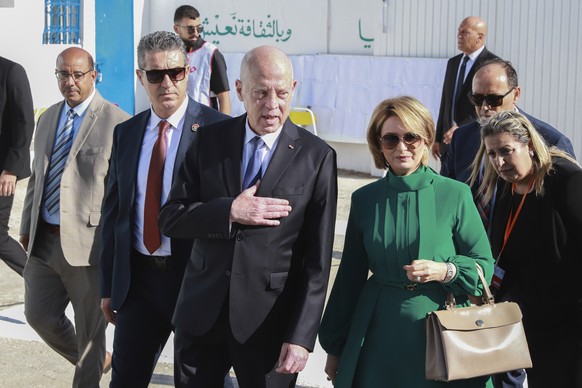 Tunisian President and candidate for re-election Kais Saied, center, and his wife Ichraf Chebil Sa�ed, leave a polling station after casting their votes, at Mnihla, in the capital Tunis, Tunisia, Sund ...