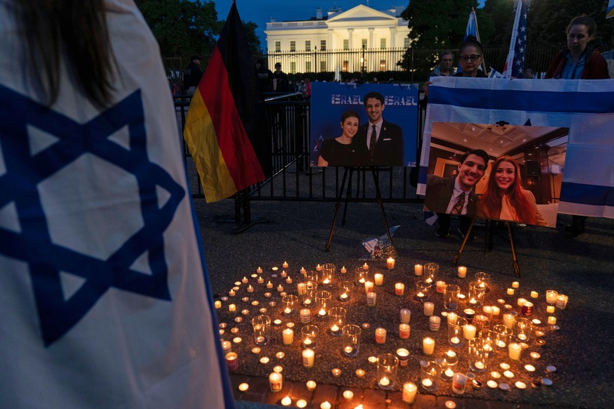 People gather to light candles in a makeshift memorial to honor Yaron Lischinsky and Sarah Milgrim who were killed as they left an event at the Capital Jewish Museum in Washington, during a candleligh ...