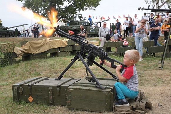 epa10132443 A boy uses a weapon loaded with blank cartridges as he attends the Tank Biathlon 2022 as part of the International Army Games ARMI-2022 at the Alabino training and tactical complex outside ...