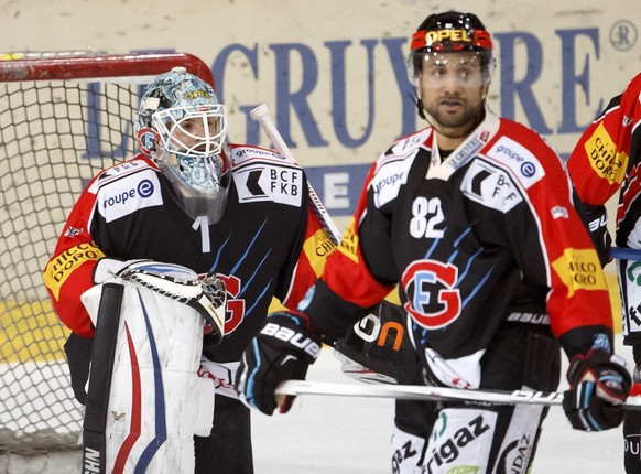 Fribourg's goaltender Benjamin Conz, left, Fribourg's Michael Ngoy, centre, Dominik Granak, of Slavakia, right, look on disappointed after taking their third goal, during the game of Nationa ...