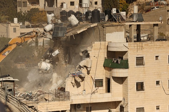 An excavator demolishes a building constructed without a permit in the Wadi Qaddum area near the Silwan neighbourhood of east Jerusalem on December 22, 2025. Israeli bulldozers tore through a four-sto ...