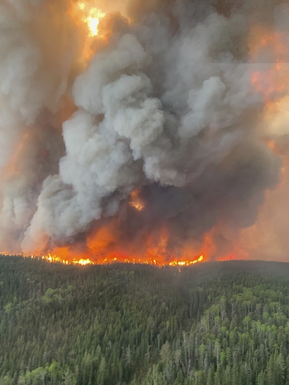 epa12144182 A handout photo made available by the government of Manitoba shows a large wildfire in the territory of Sherridon, Manitoba, Canada, 27 May 2025 (issued 29 May 2025). Thousands of people i ...
