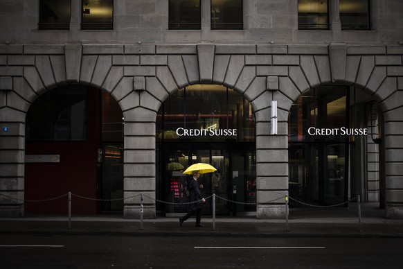 A person walks past a logo of the Swiss bank Credit Suisse in Zurich, Switzerland, on Friday, March 24, 2023. (KEYSTONE/Michael Buholzer).