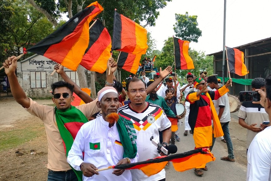 Football fans attend the unveiling of Germany's 7.5 kilometres (4.7 miles)-long national flag commisioned by Bangladeshi farmer Amjad Hossain (2L) in Magura district on June 10, 2026, on the eve  ...