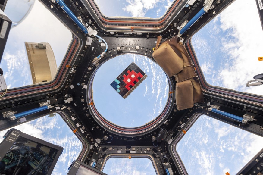 Un vaisseau spatial, dans lequel on peut apercevoir une mosaïque de l'artiste français Invader.
