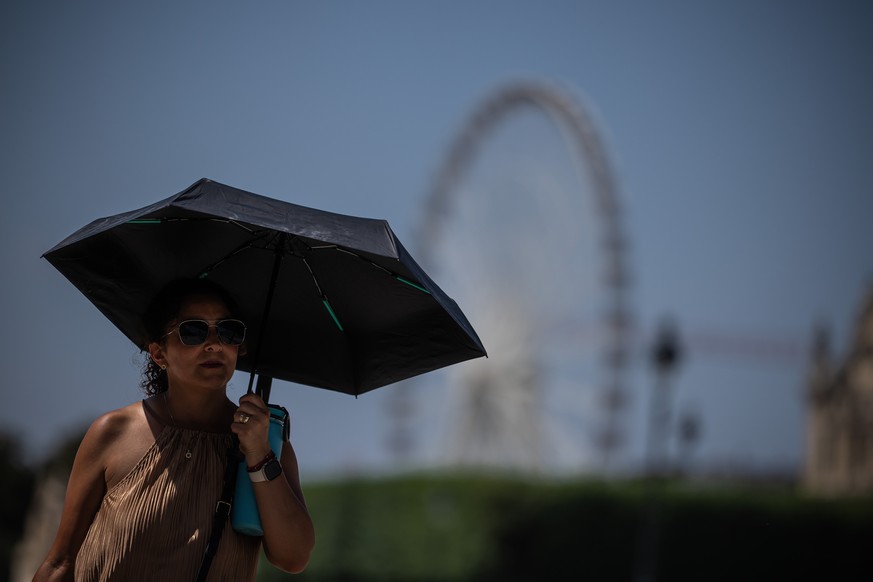 A tourist with an umbrella walks in Paris during a heat wave, Saturday, June 27, 2026. (AP Photo/Aurelien Morissard)
France Extreme Weather Heat