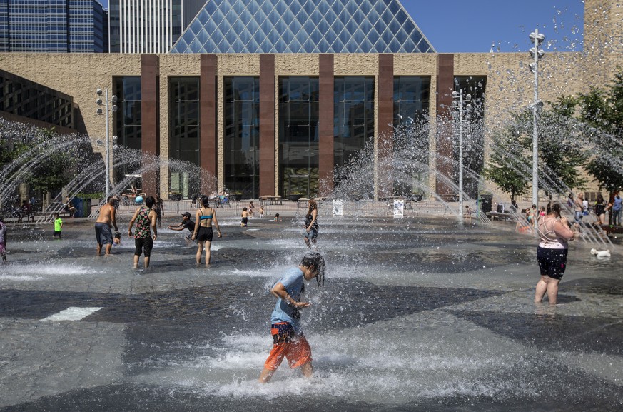 People cool off in the city hall pool, as temperatures hit 37 degrees Celsius in Edmonton, Alberta, on Wednesday, June 30, 2021. (Jason Franson/The Canadian Press via AP)