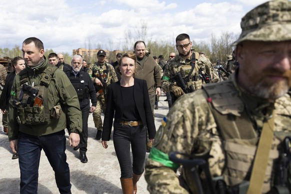 Irene Kaelin, President of the Swiss National Assembly, center, surrounded by members of the Ukrainian military, leaves the Hostomel airfield near Kiev, Ukraine, which was destroyed by Russian invader ...