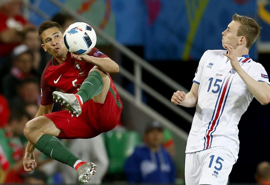 epa05365458 Raphael Guerreiro (L) of Portugal and Jon Dadi Bodvarsson of Iceland in action during the UEFA EURO 2016 group F preliminary round match between Portugal and Iceland at Stade Geoffroy Guic ...