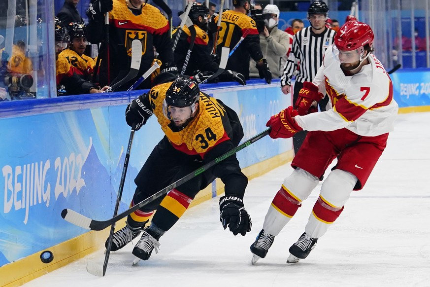 Germany&#039;s Tom Kuhnhackl (34) and China&#039;s Jieke Kailiaosi (Jake Chelios) (7) chase after the puck during a preliminary round men&#039;s hockey game at the 2022 Winter Olympics, Saturday, Feb. ...
