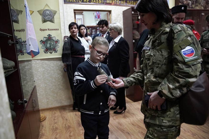 Schoolboy Ivan Ilyin, 7, examines a shell casing at a school museum after a ceremony led by local patriotic movements to reward him for the drawings, messages and gifts he sent to Russian soldiers tak ...