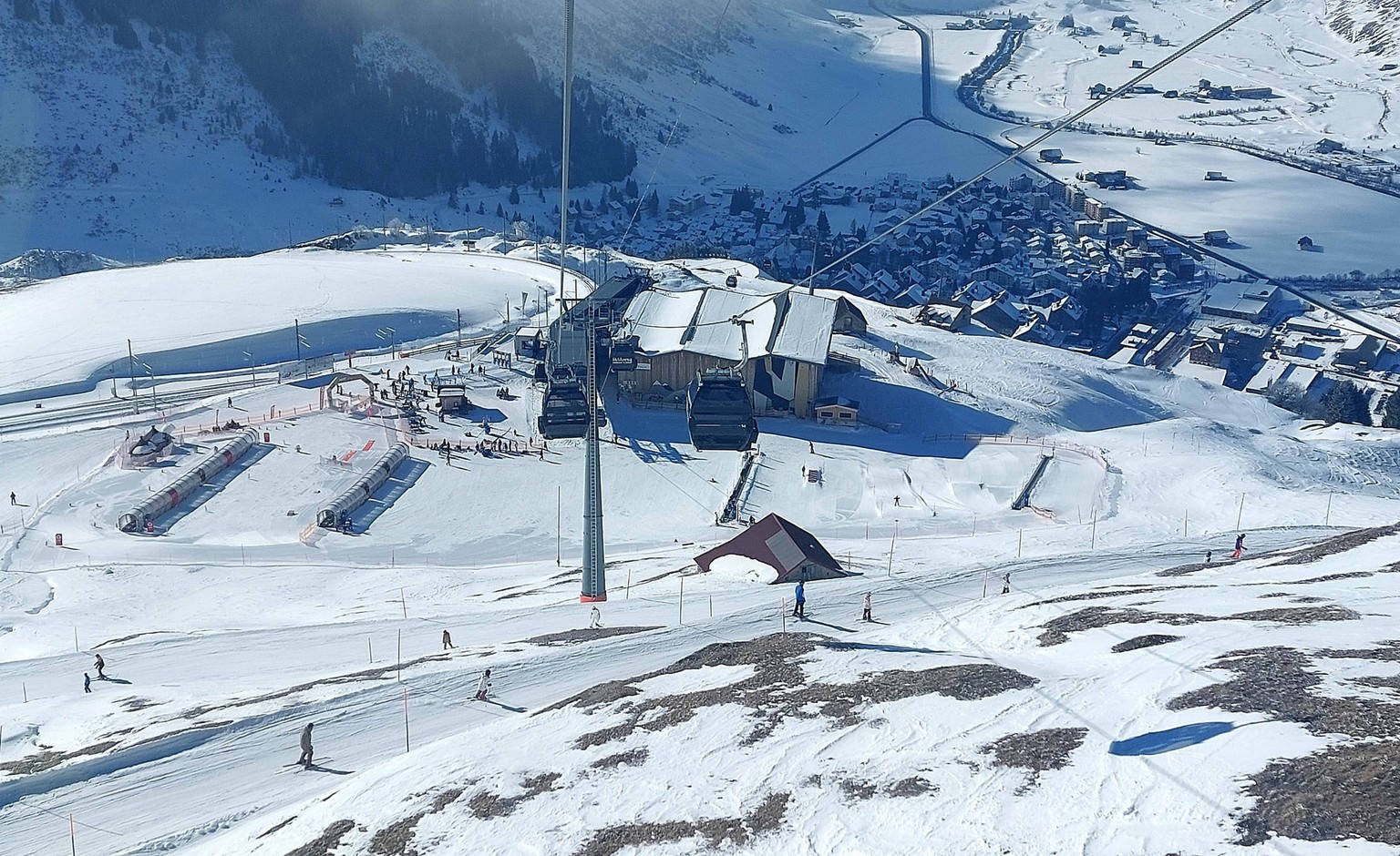 Themenbild - Skifahren, Skifahrer auf Skipisten in der Alpenregion Andermatt, Gotthardmassiv, Kanton Uri, Schweiz, Alpengletscher Skifahren in Andermatt, Skifahren bei Schneemangel, teilweise grüne Wi ...