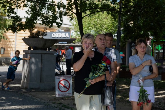 (FILES) This photograph taken on August 28, 2026 shows shows attendees holding flowers as they take part in a commemorative event ahead of the Day of Remembrance for the Defenders of Ukraine in Bereho ...