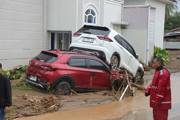 This photo released by Indonesia&#039;s National Disaster Management Agency (BNPB) on Thursday, Nov. 27, 2025, shows people inspect the damage at a flood hit neighborhood in Padang, West Sumatra, Indo ...