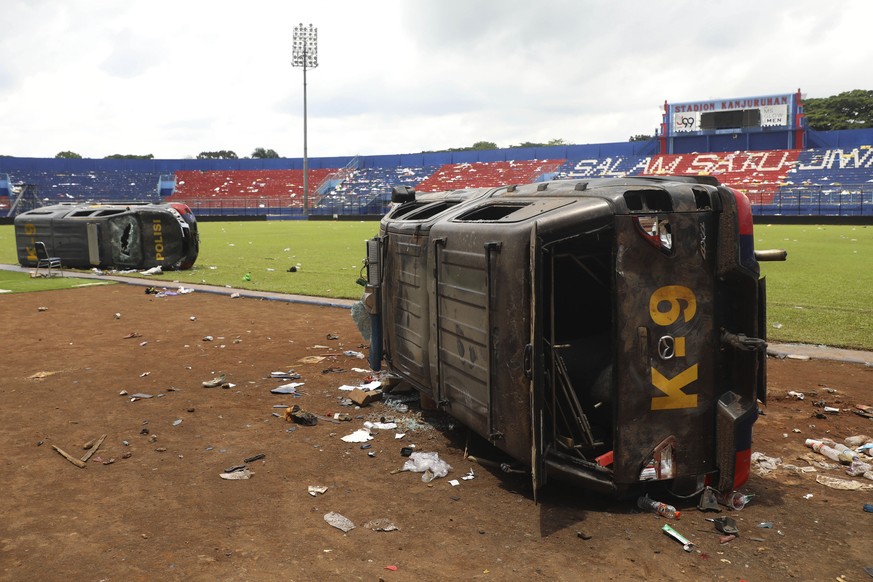 Police cars wrecked in soccer riots are seen on the pitch at Kanjuruhan Stadium in Malang, East Java, Indonesia, Sunday, Oct. 2, 2022. Panic at an Indonesian soccer match Saturday left over 150 people ...