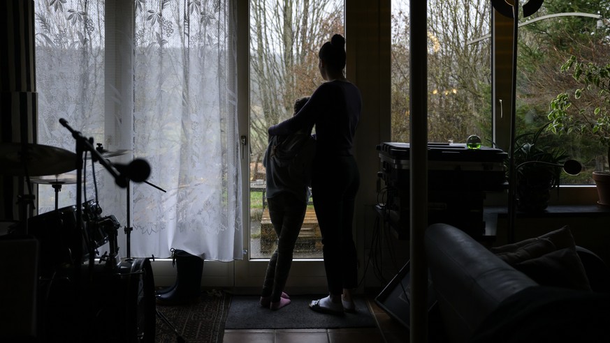 epa09877023 Mascha (R), a Ukrainian refugee, and her daughter Vlada (L), look out the window of the house of Tom Loosli, a resident of Tramelan, in the Bernese Jura, Switzerland, 07 April 2022. Tom we ...