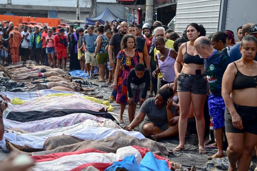 Une femme pleure à côté de corps alignés sur la place Sao Lucas de la favela Vila Cruzeiro.