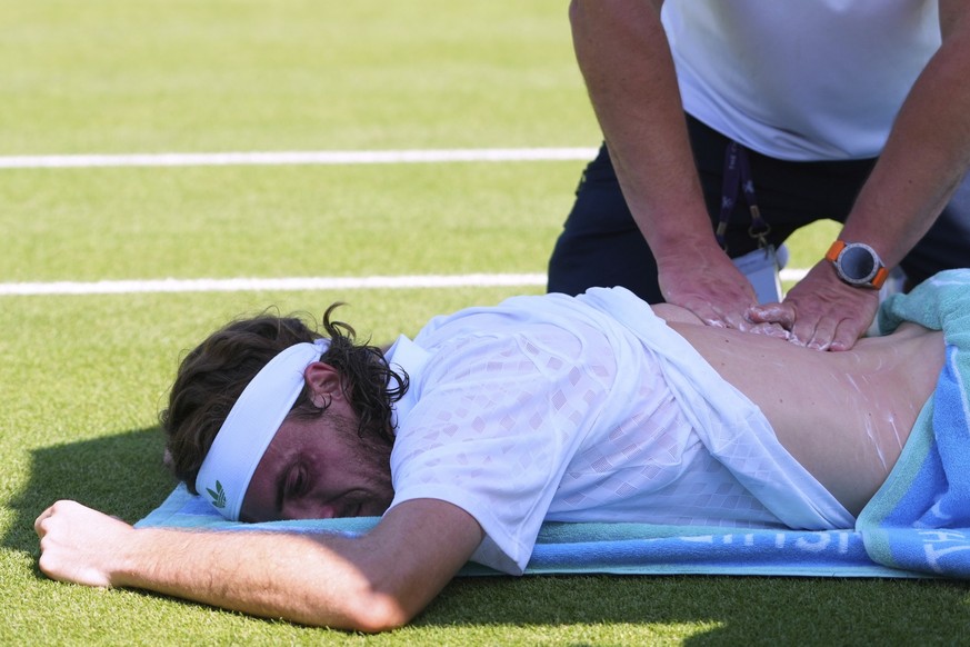 Stefanos Tsitsipas of Greece receives treatment during his first round men's single match against Valentine Royer of France at the Wimbledon Tennis Championships in London, Monday, June 30, 2025. ...