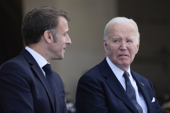 President Joe Biden and French President Emmanuel Macron, talk during ceremonies to mark the 80th anniversary of D-Day, Thursday, June 6, 2024, in Normandy. (AP Photo/Evan Vucci)