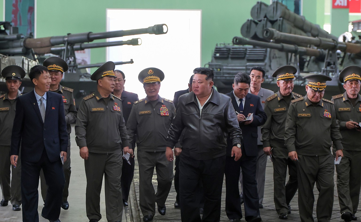 epaselect epa12940314 A photo released by the official Korean Central News Agency (KCNA) shows North Korean leader Kim Jong Un (C) inspecting a munitions factory at an undisclosed location in North Ko ...