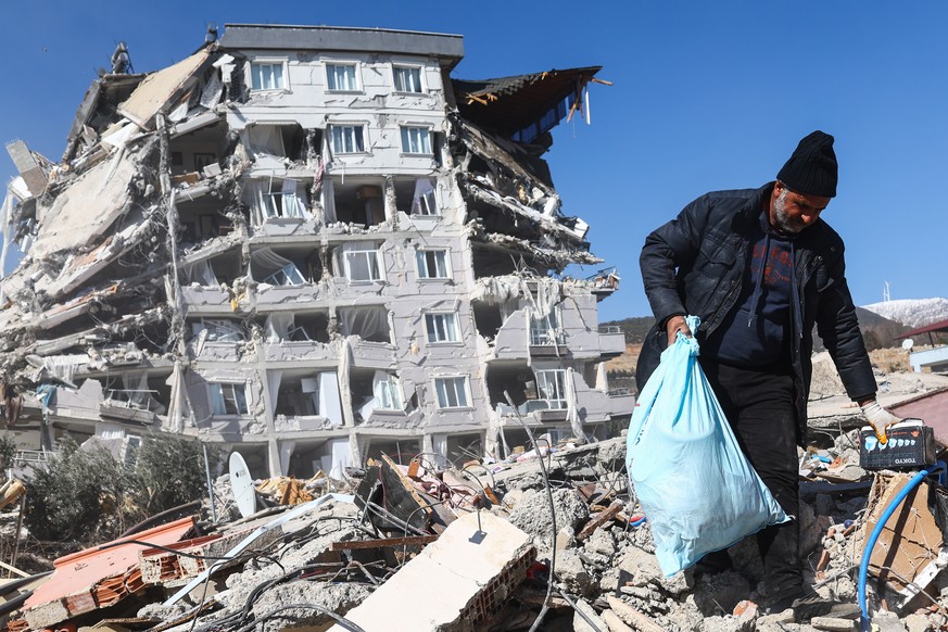 Un homme tente de récupérer quelques effets personnels dans les décombres à Gaziantep, en Turquie.