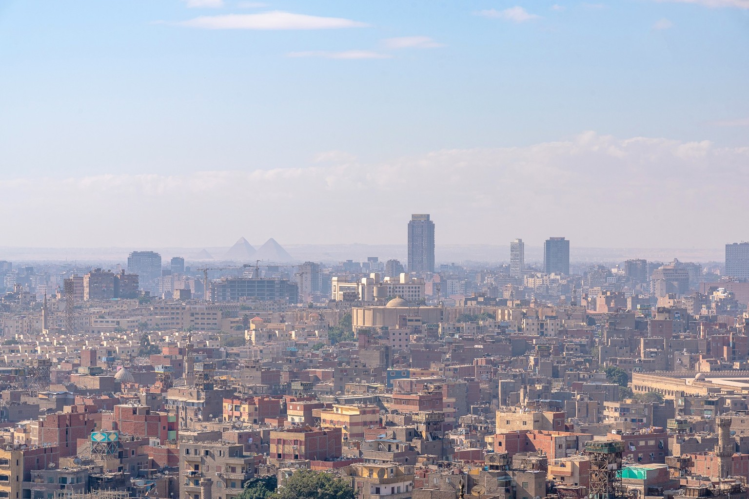 This photo was taken from the Cairo Citadel during daytime. The visibility is not clear due to humidity and polution. The pyramids of Giza can be seen far away across the town.