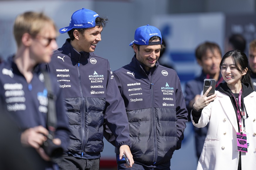 Williams driver Alexander Albon of Thailand, center left, and Carlos Sainz of Spain arrive at the Suzuka Circuit for the first practice session for the Japanese Formula One Grand Prix in Suzuka, centr ...