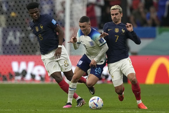 France&#039;s Aurelien Tchouameni, left, England&#039;s Phil Foden, center, and France&#039;s Antoine Griezmann challenge for the ball during the World Cup quarterfinal soccer match between England an ...
