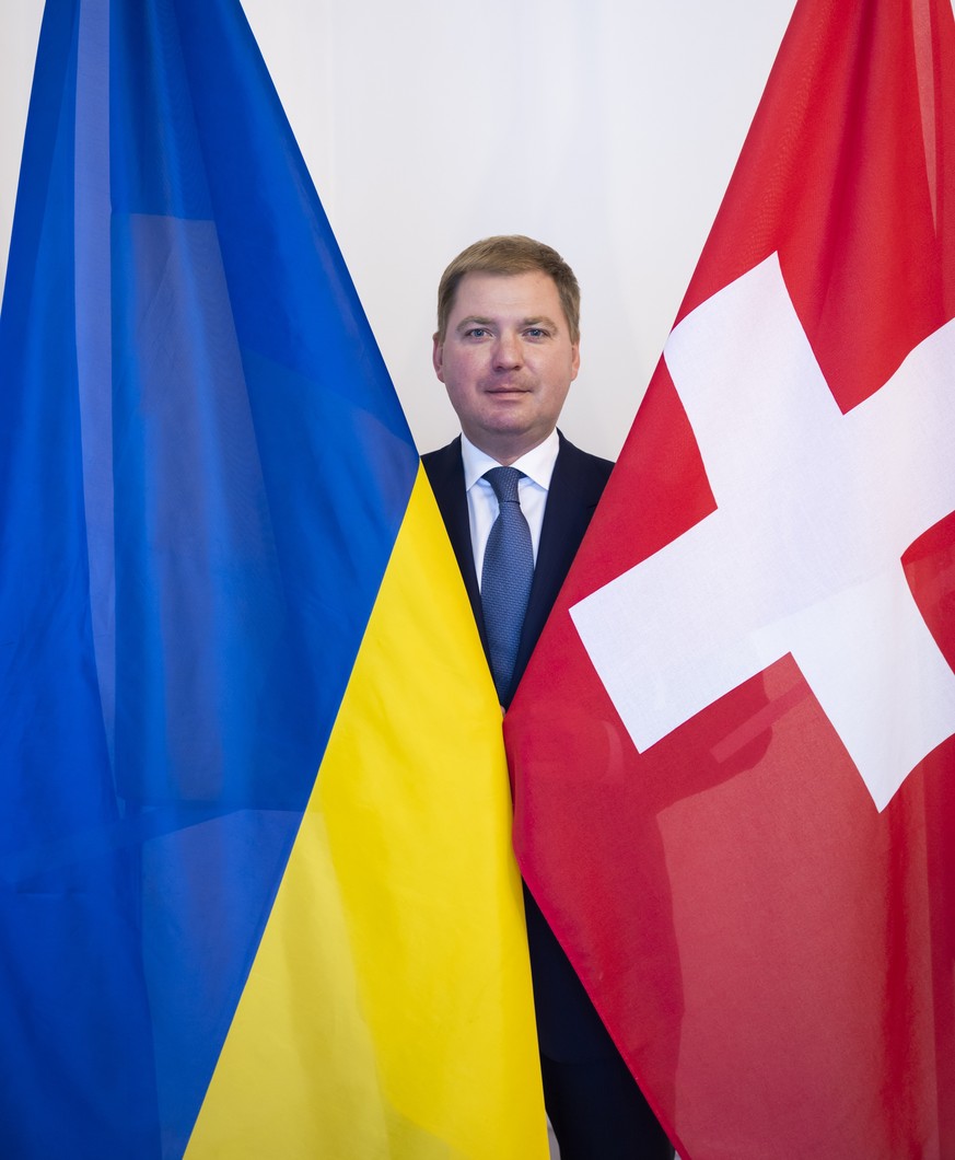 Artem Rybchenko, Ukrainischer Botschafter in der Schweiz, posiert zwischen der Ukrainischen und der Schweizer Flagge, nach einer Medienkonferenz in der Ukrainischen Botschaft, am Dienstag, 23. August  ...