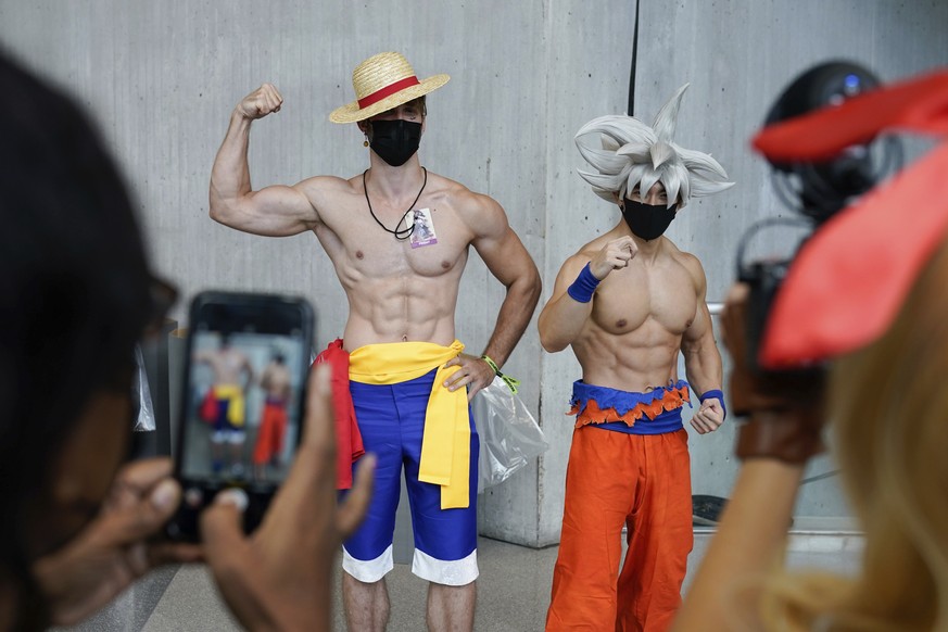 Men dressed as anime characters pose for pictures at New York Comic Con in New York, Friday, Oct. 8, 2021. Although the convention was canceled last year because of COVID-19, this year attendees were  ...