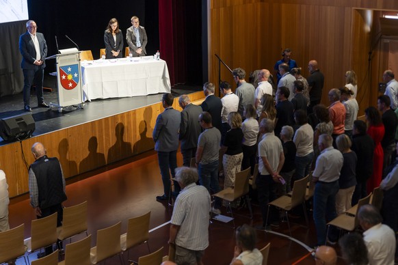 epa13042162 Nicolas Feraud (L), mayor of Crans-Montana, and municipal councillors Marielle Clivaz (C) and Patrick Clivaz (R) observe a minute of silence during a primary assembly in Crans-Montana, Swi ...