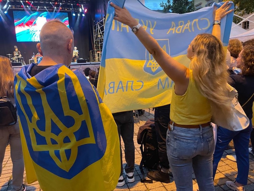 Des drapeaux ukrainiens sont brandis lors du concert sur la Piazza Manzoni.
