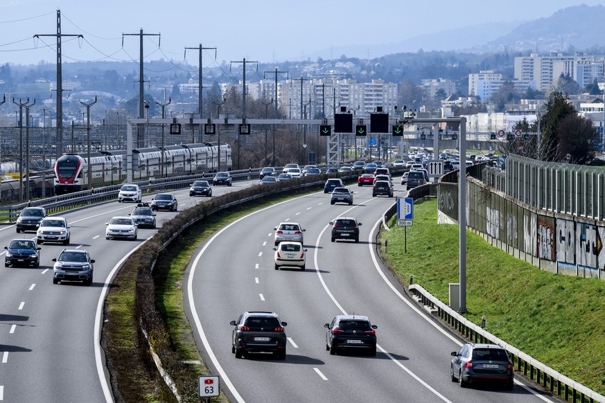 Des vehicules circulent sur l&#039;autoroute A1 Lausanne-Geneve pres d&#039;Ecublens a cote d&#039;un train des CFF circulant sur une ligne ferroviaire le samedi 2 mars 2024 a Denges. La bande d&#039; ...