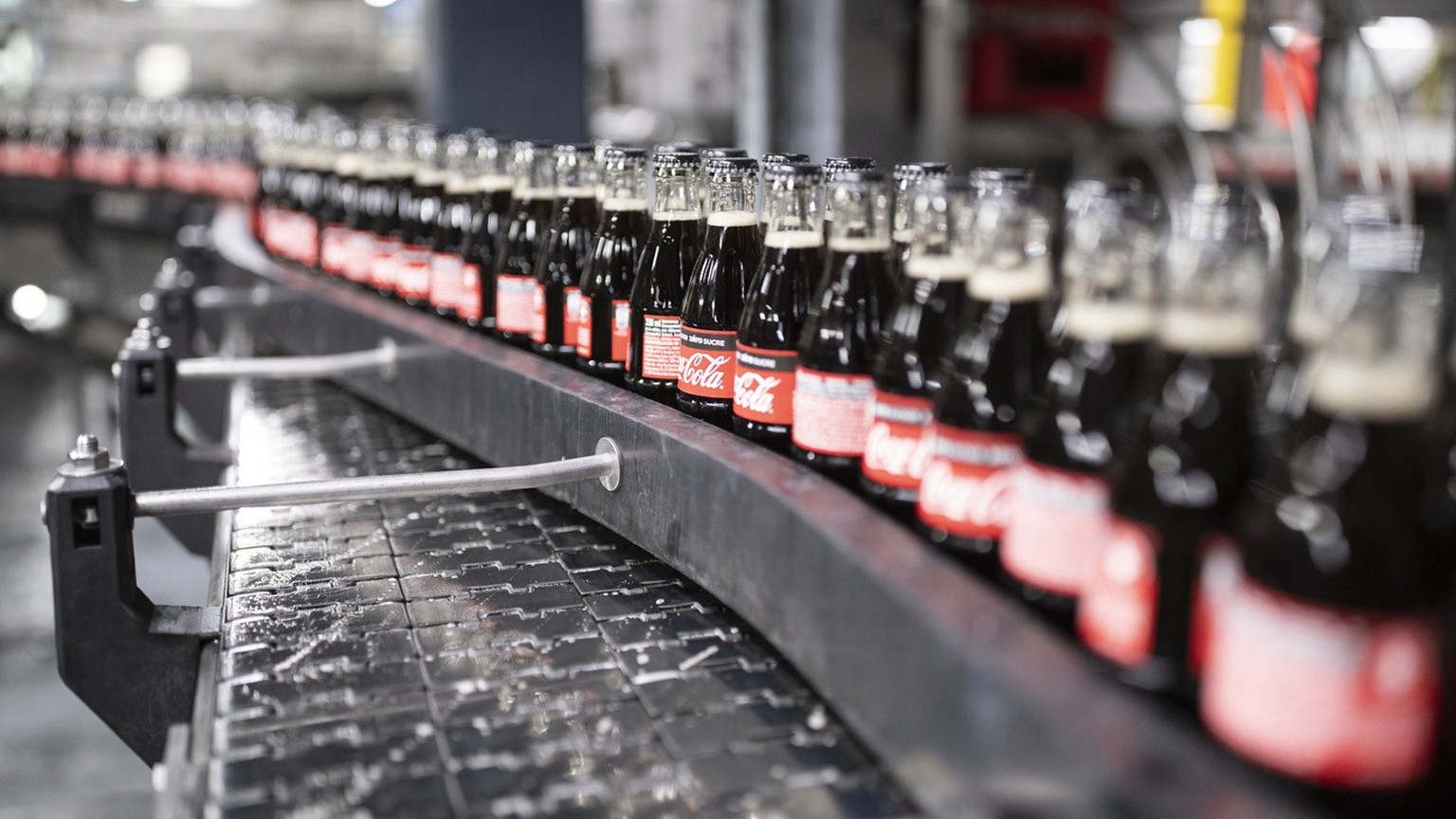 Coca-Cola-Glasflaschen werden auf einem Foerderband durch die Coca-Cola-Abfuellanlage befoerdert, fotografiert am 7. September 2020 am Produktionsstandort in Bruettisellen.