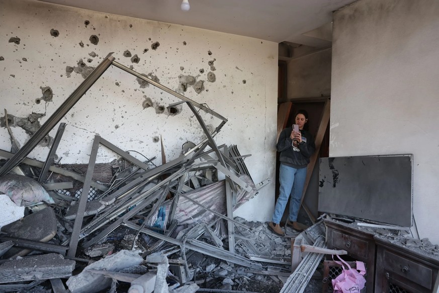 Une femme examine les dégâts causés à une maison près de Netanya, en Israël, qui a été touchée par une roquette du Hezbollah.