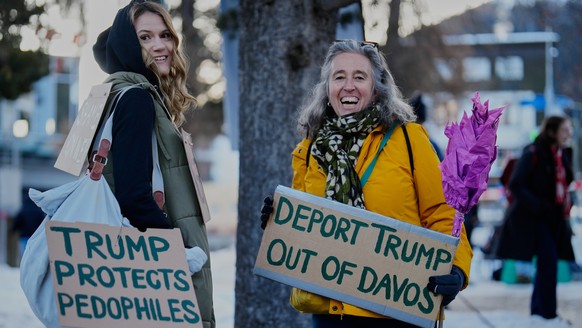 Two women with posters attend a demonstration against United States President Donald Trump and the Annual Meeting of the World Economy Forum in Davos, Switzerland, Sunday, Jan. 18, 2026. (AP Photo/Mar ...