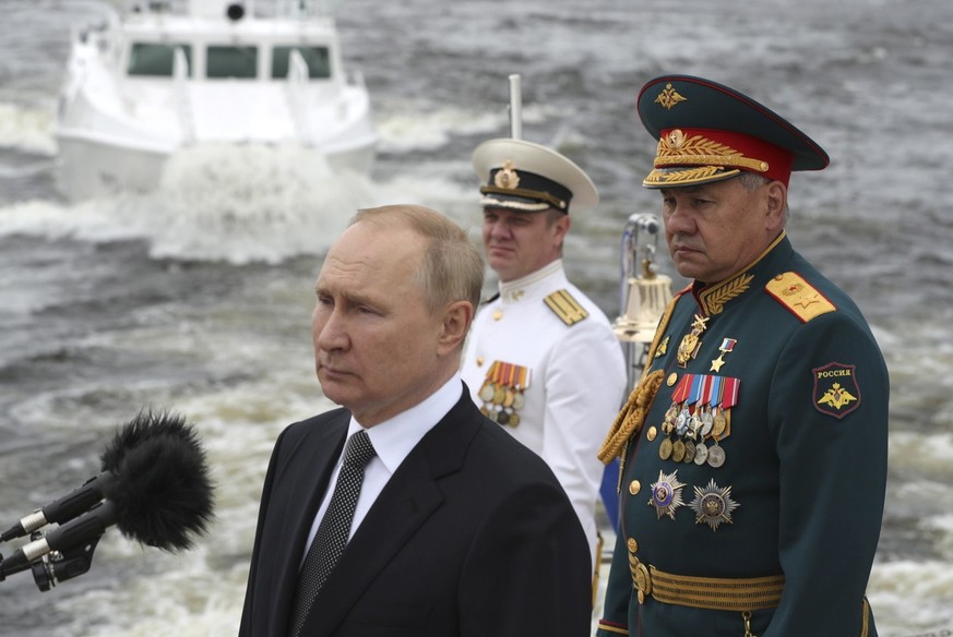 epa10099697 Russian President Vladimir Putin (L), Russian Defence Minister Sergei Shoigu (R) and Admiral Nikolai Yevmenov, Commander-in-Chief of the Russian Navy (C) review warships during the the Mai ...