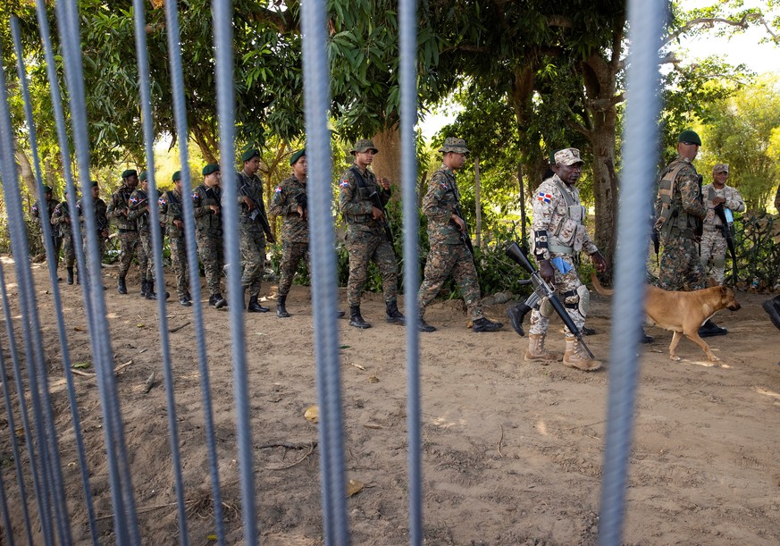 epa09774917 Dominican soldiers patrol during the inauguration, by the President of Dominican Republic, Luis Abinader, of the works of the new border fence that will separate the Dominican Republic and ...