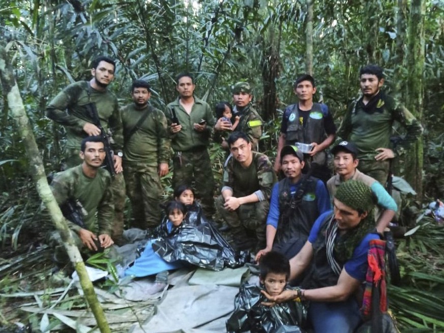 In this photo released by Colombia&#039;s Armed Forces Press Office, soldiers and Indigenous men pose for a photo with the four Indigenous children who were missing after a deadly plane crash, in the  ...