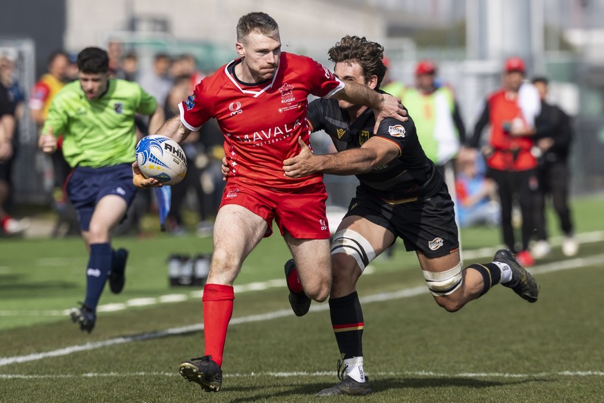 Switzerland's Paul Davallet, left, fights for the ball during the Rugby Europe Championship 2026 match between Switzerland and Germany, in Municipal Stadium of Yverdon-les-Bains, Switzerland, Sat ...