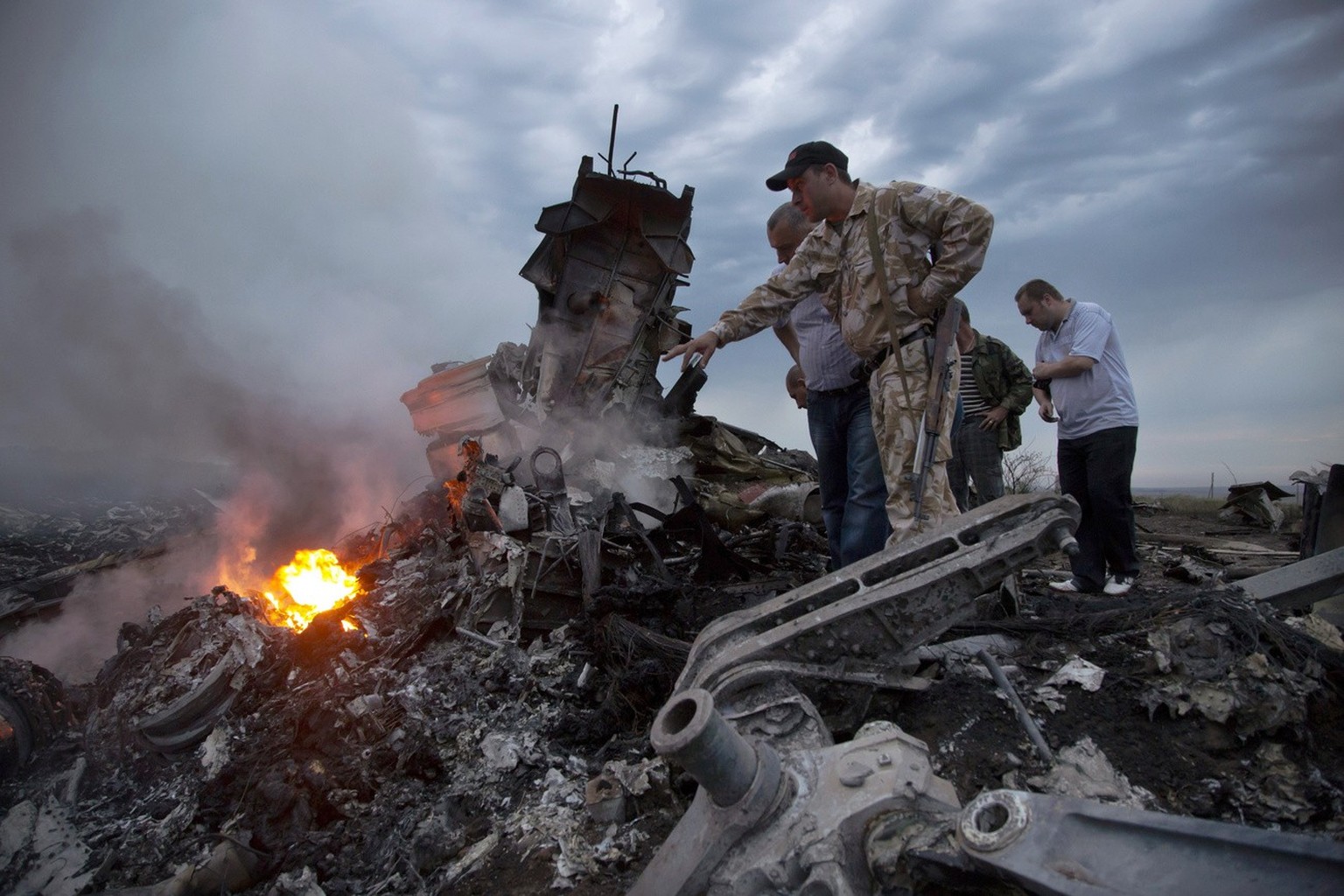 FILE - People inspect the crash site of a passenger plane near the village of Grabovo, Ukraine, on July 17, 2014. A Dutch court on Thursday is set to deliver verdicts in the long-running trial of thre ...