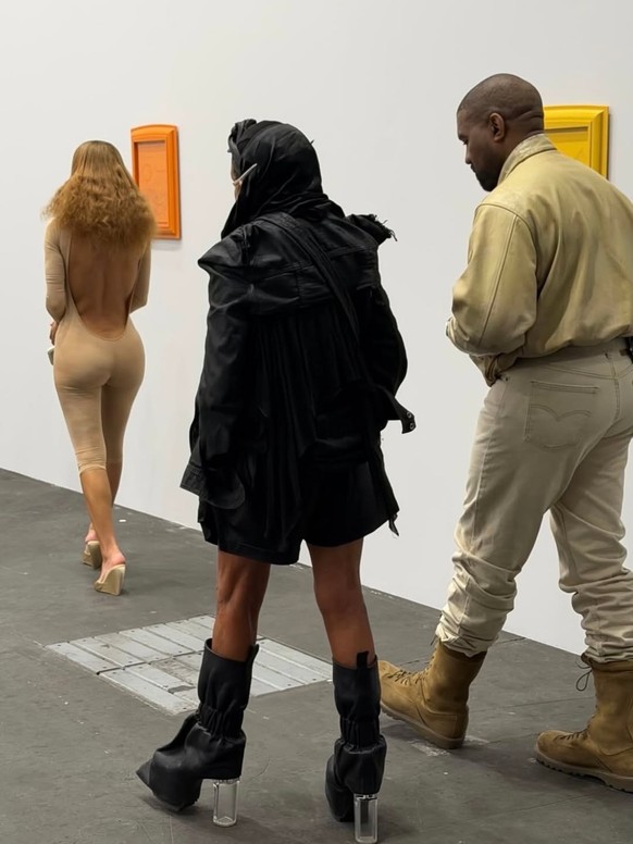 Ye était accordé à la tenue de sa femme, qui abordait une combinaison moulante beige et des talons assortis.
