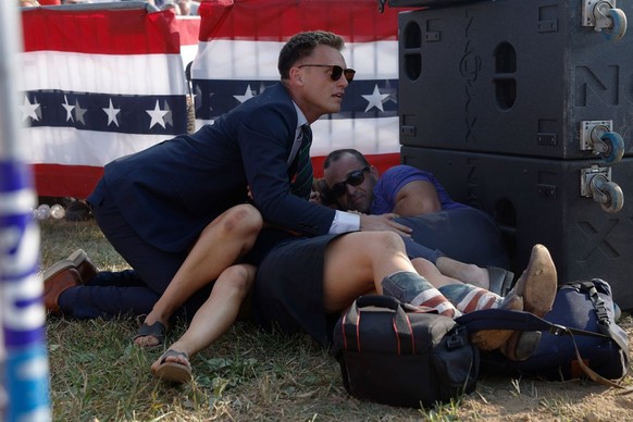 BUTLER, PENNSYLVANIA - JULY 13: A Secret Service member and members of the crowd are seen at republican presidential candidate former President Donald Trump's rally on July 13, 2024 in Butler, Pe ...