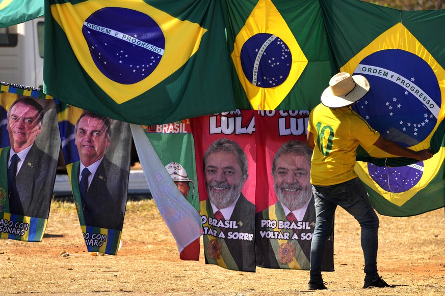 FILE - Presidential election campaign flags hang for sale, featuring the faces of both current President Jair Bolsonaro, left, and former President Luiz Inacio Lula da Silva, outside the Supreme Elect ...