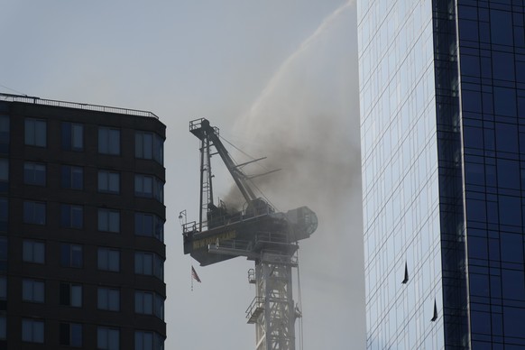 Smoke rises from a construction crane that caught fire in Manhattan, Wednesday, July 26, 2023, in New York. The crane lost its long arm, which smashed against a nearby building, dangled and then plumm ...